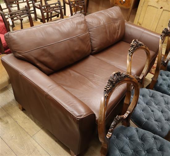 A modern brown leather two seater settee